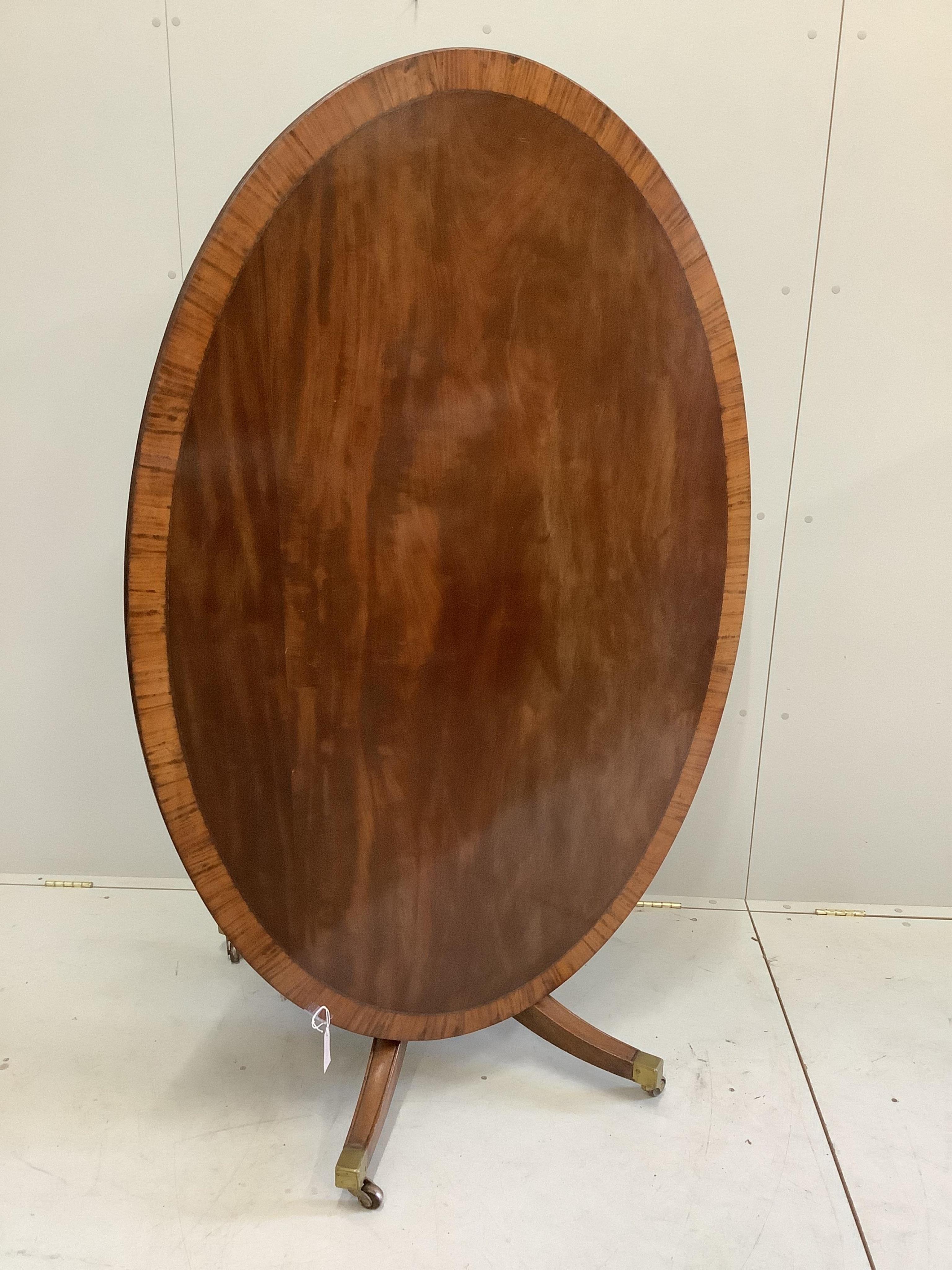 A George III and later satinwood banded oval mahogany tilt top dining table, width 152cm, depth 103cm, height 75cm